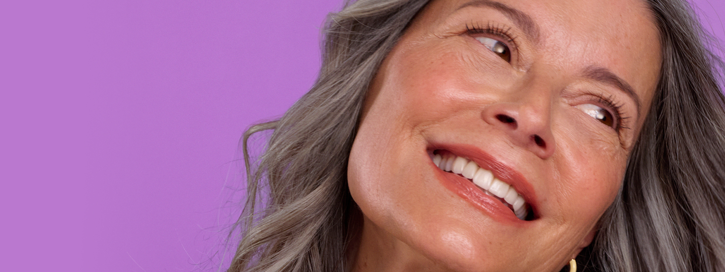 Woman smiling with long hair and head tilted